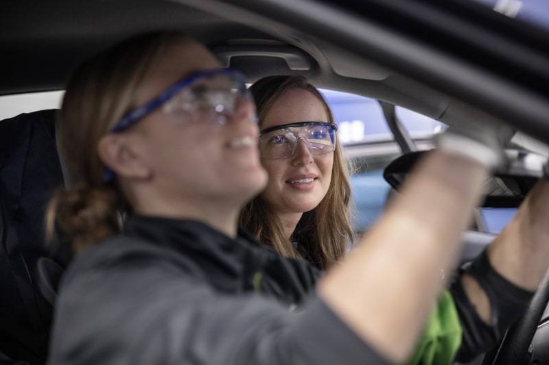 Två kvinnor inspekterar en bil